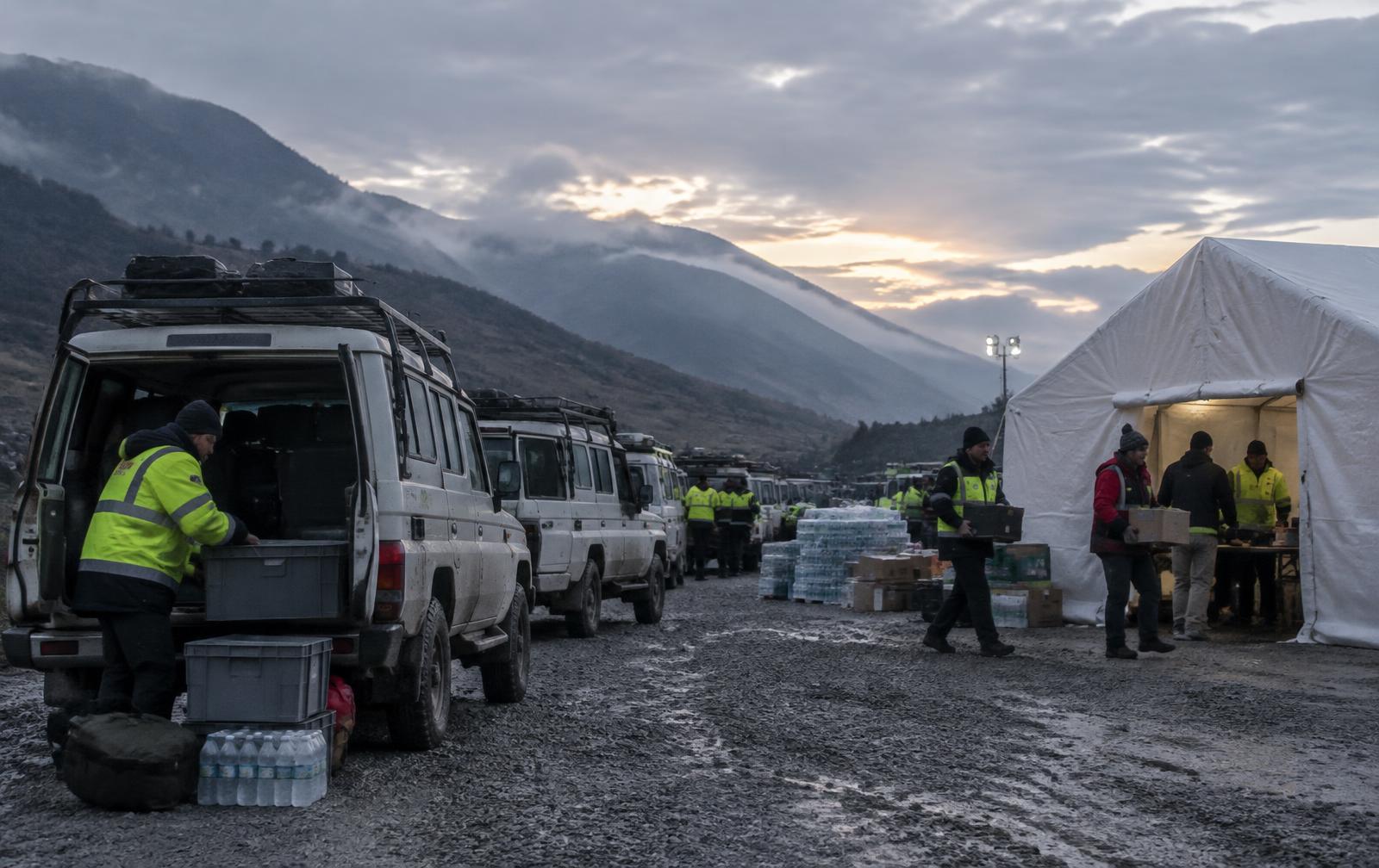 Response vehicles and staging tent at a relief site at dawn